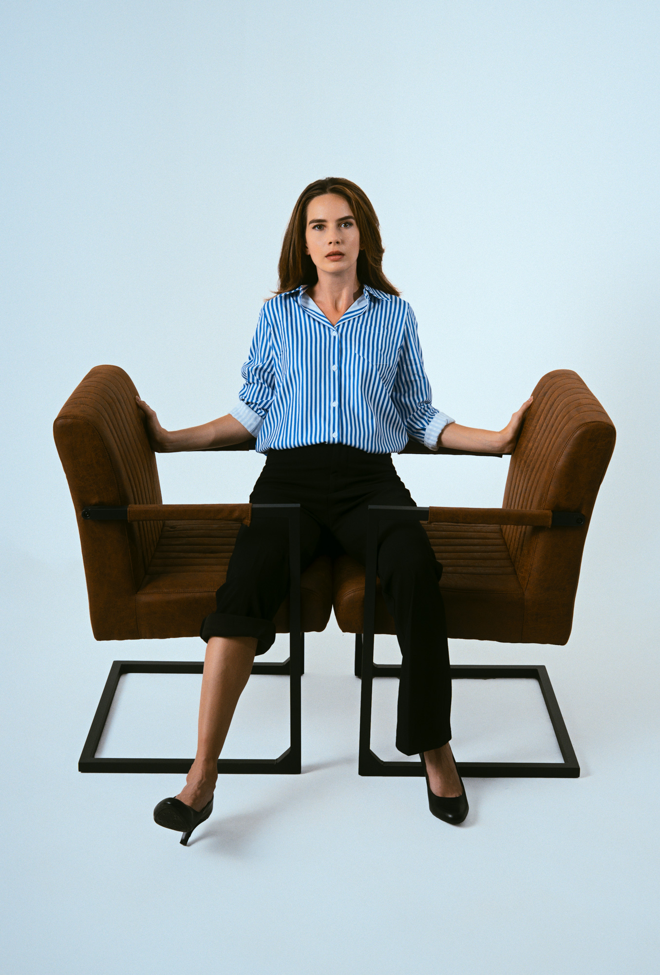 Actress Julie seated in character on a studio chair